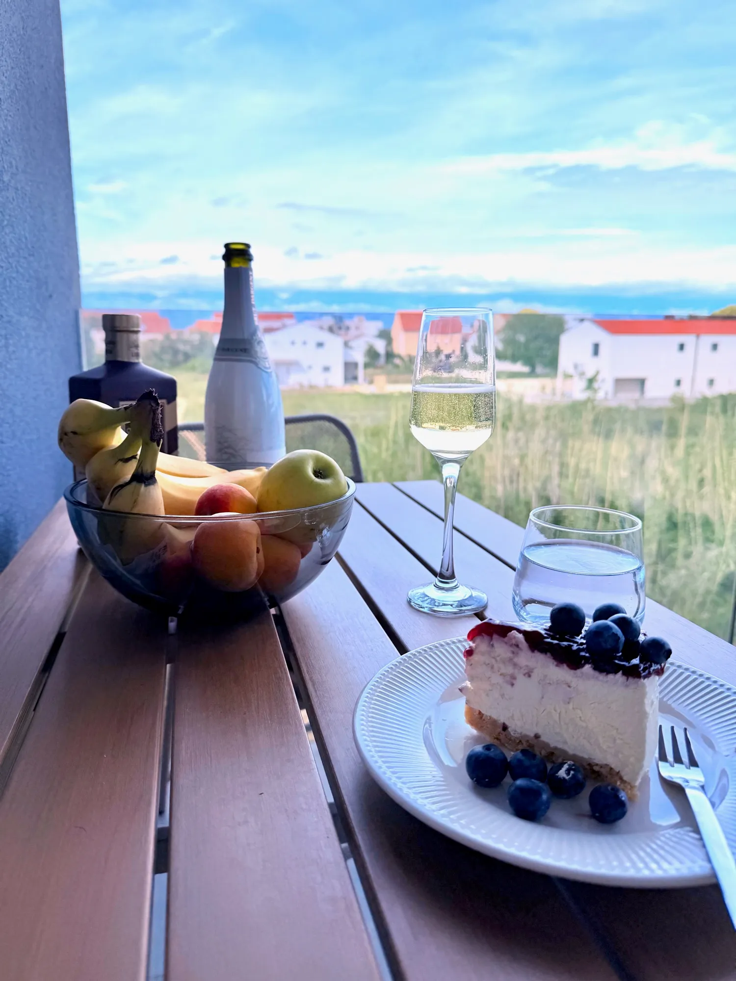 Gedeckter Balkontisch mit Obst, Sekt und Kuchen vor Velebit-Kulisse